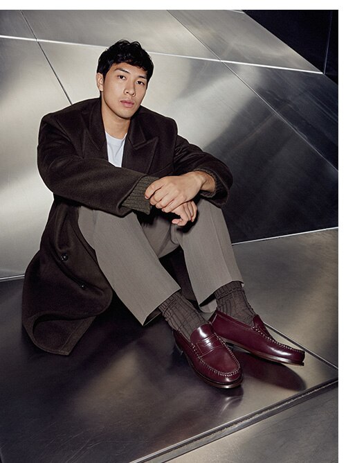 Male model in brown leather shoes siiting on the silver floor