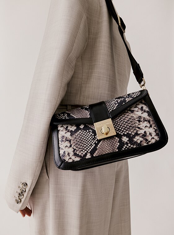 Woman carrying the snake print crossbody bag Waterloo by Russell and Bromley