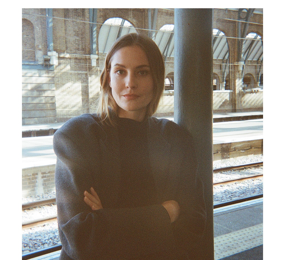 Female model standing on train station platform